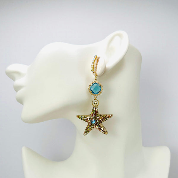 Handgemaakt statement oorbel earrings aqua cowrie shell handgemaakt door MUZE earrings. Gratis geleverd binnen nederland en belgie.