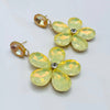 Handgemaakt statement oorbel earrings mirrored pastel yellow flower handgemaakt door MUZE earrings. Gratis geleverd binnen nederland en belgie.